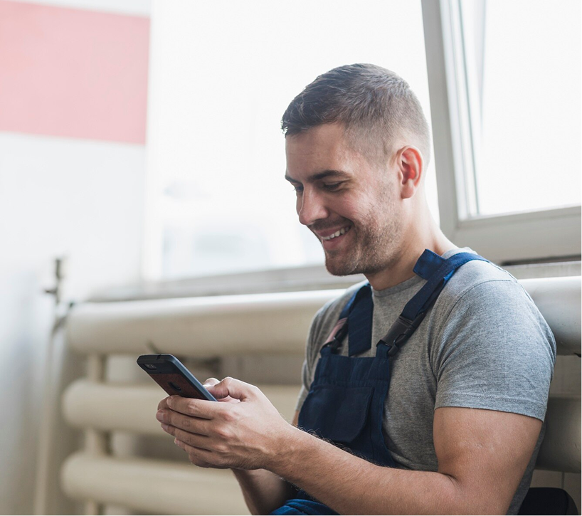 roofer-smiling-looking-at-phone